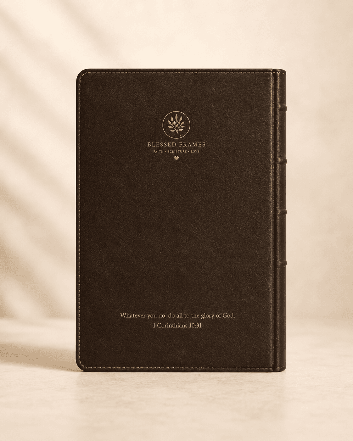 Back cover — brown leather with the Blessed Frames mark in gold at the top, and an engraved verse at the bottom.
