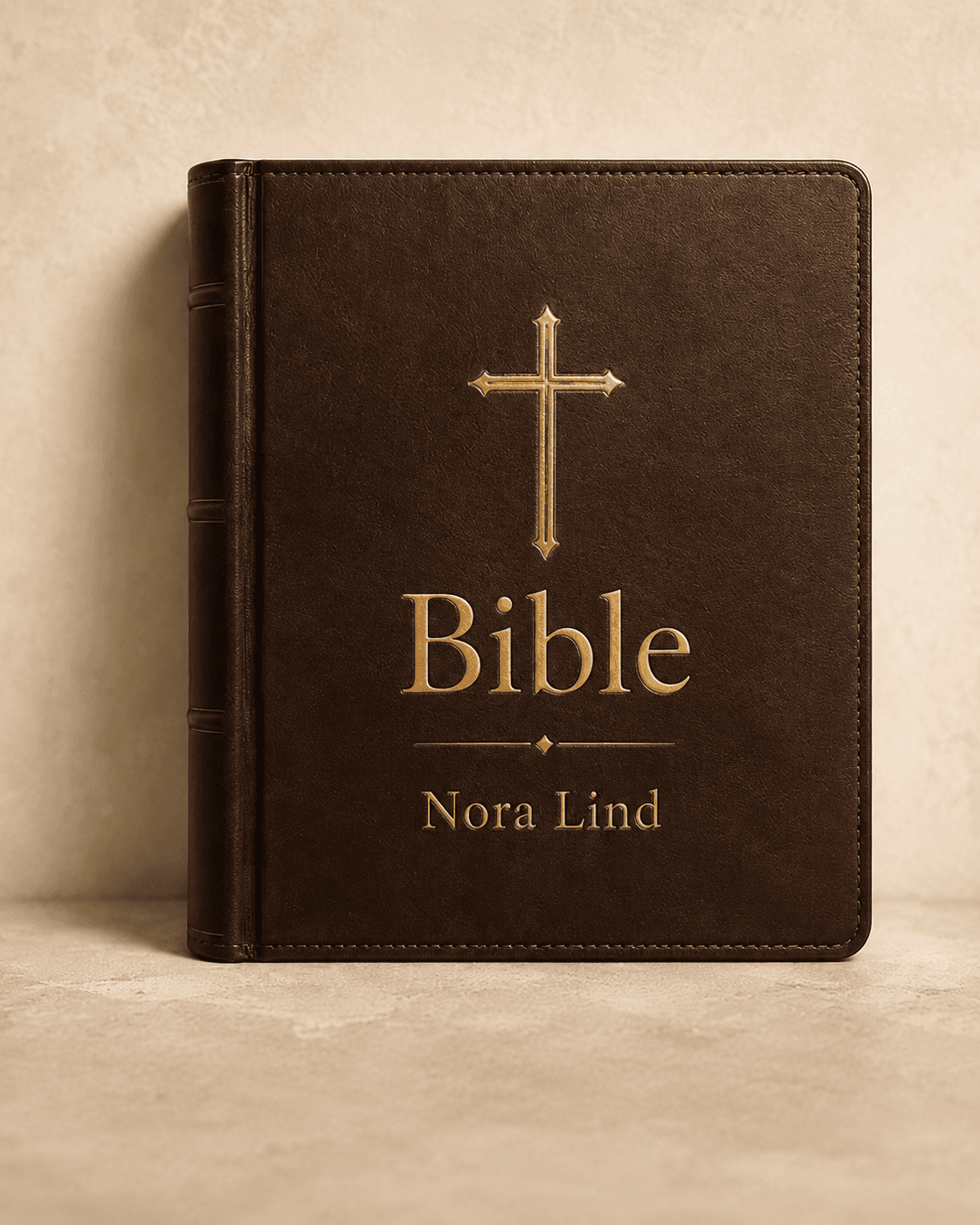 Front cover — brown leather hardcover with gold cross, the word 'Bible' in gold serif, and an engraved name inside a thin gold-rule ribbon.